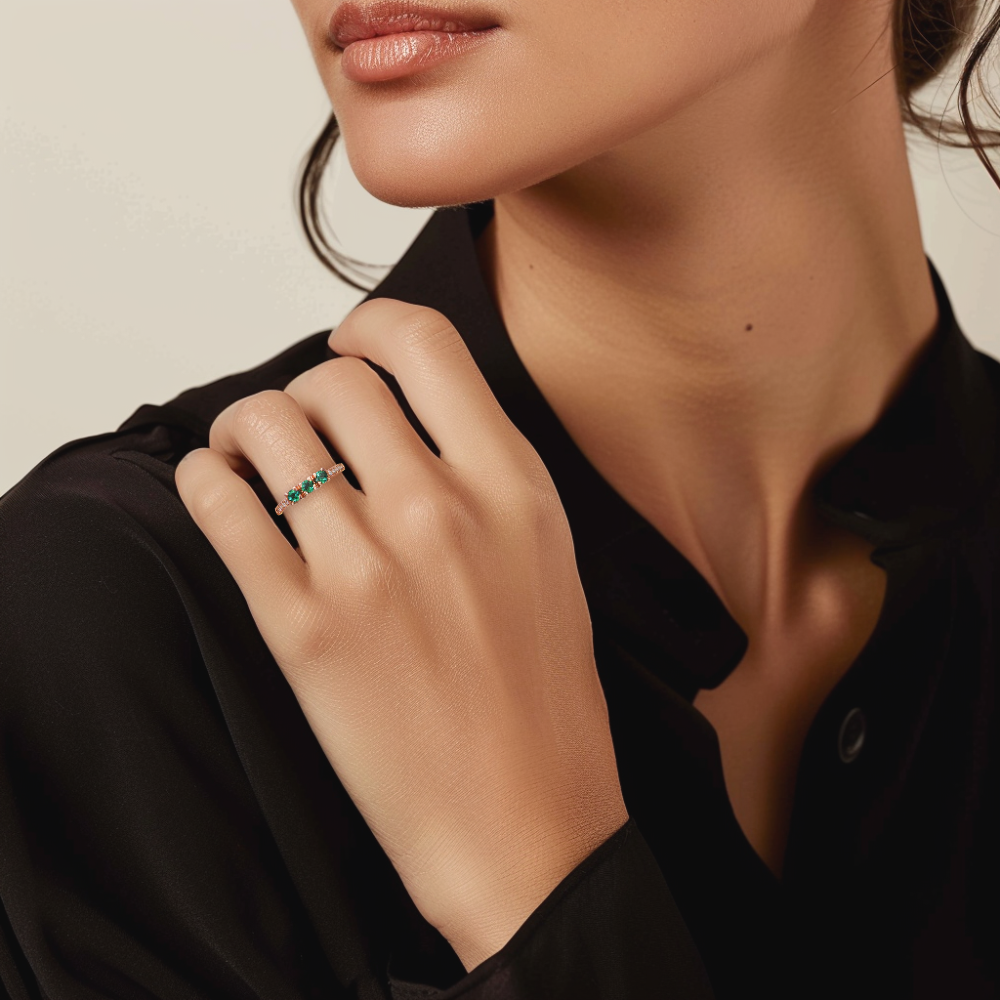 Prsten z růžového zlata se zelenými turmalíny na ruce ženy