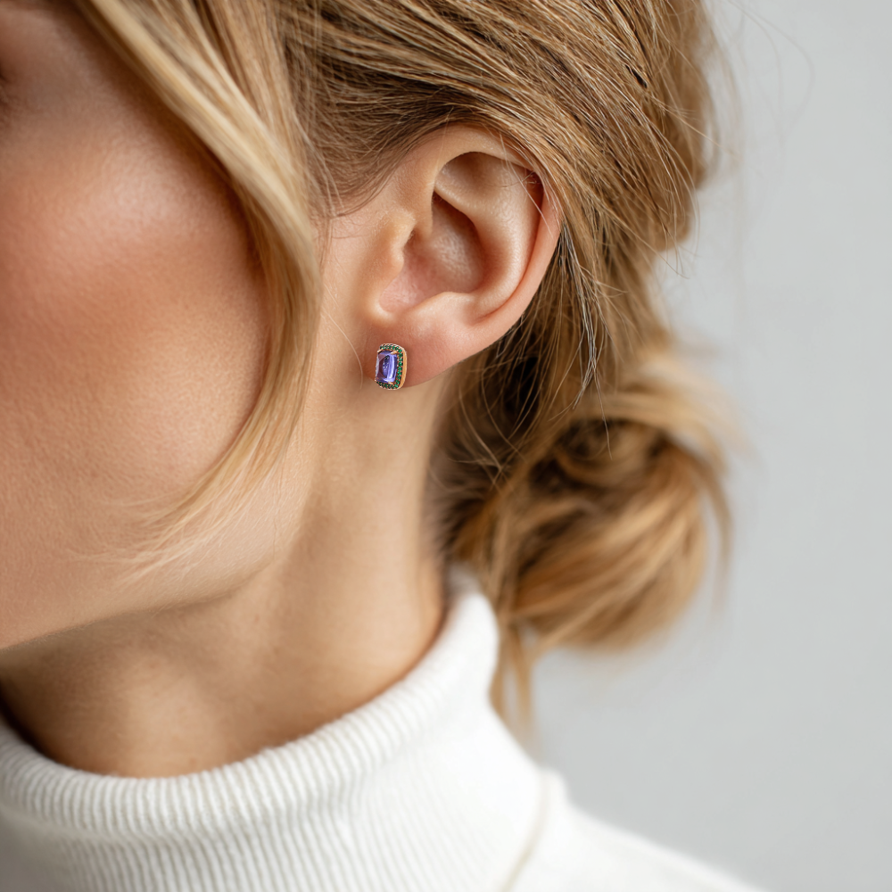Nausnice z ruzoveho zlata s tanzanity a smaragdy na uchu modelky
